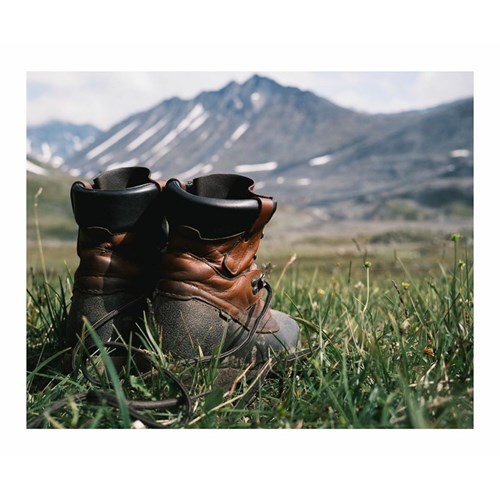 A pair of boots in a grassy field.