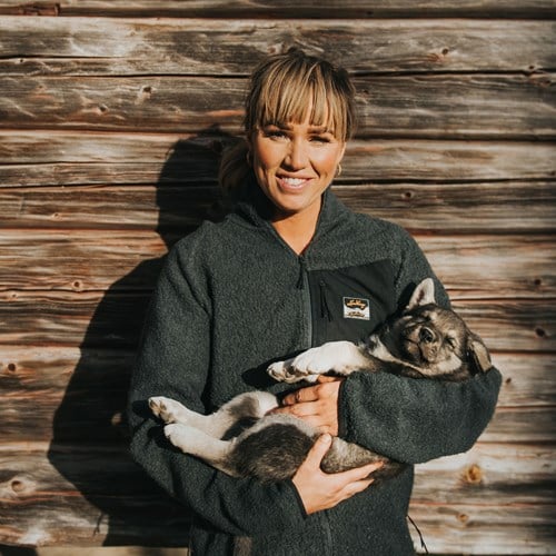 A woman holding a couple of cats.