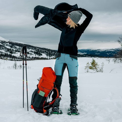Een man die een vrouw op zijn rug houdt op een besneeuwde berg.