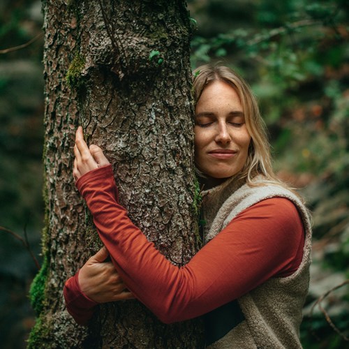 A person leaning against a tree.